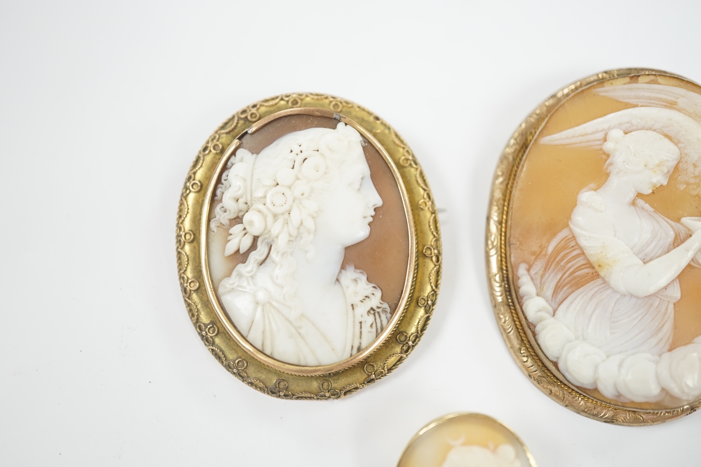 Two yellow metal mounted oval cameo shell brooches, the largest depicting Diana and the Eagle, 55mm and one other gilt metal mounted oval cameo shell brooch.